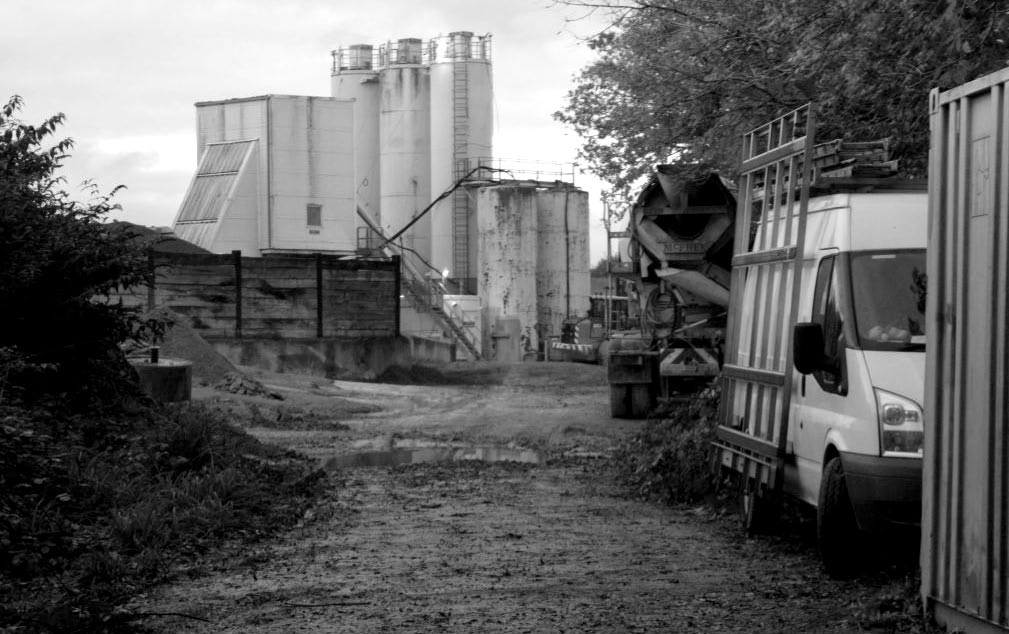 Beyond gates across the track bed, industrial use of the site of triangular junction