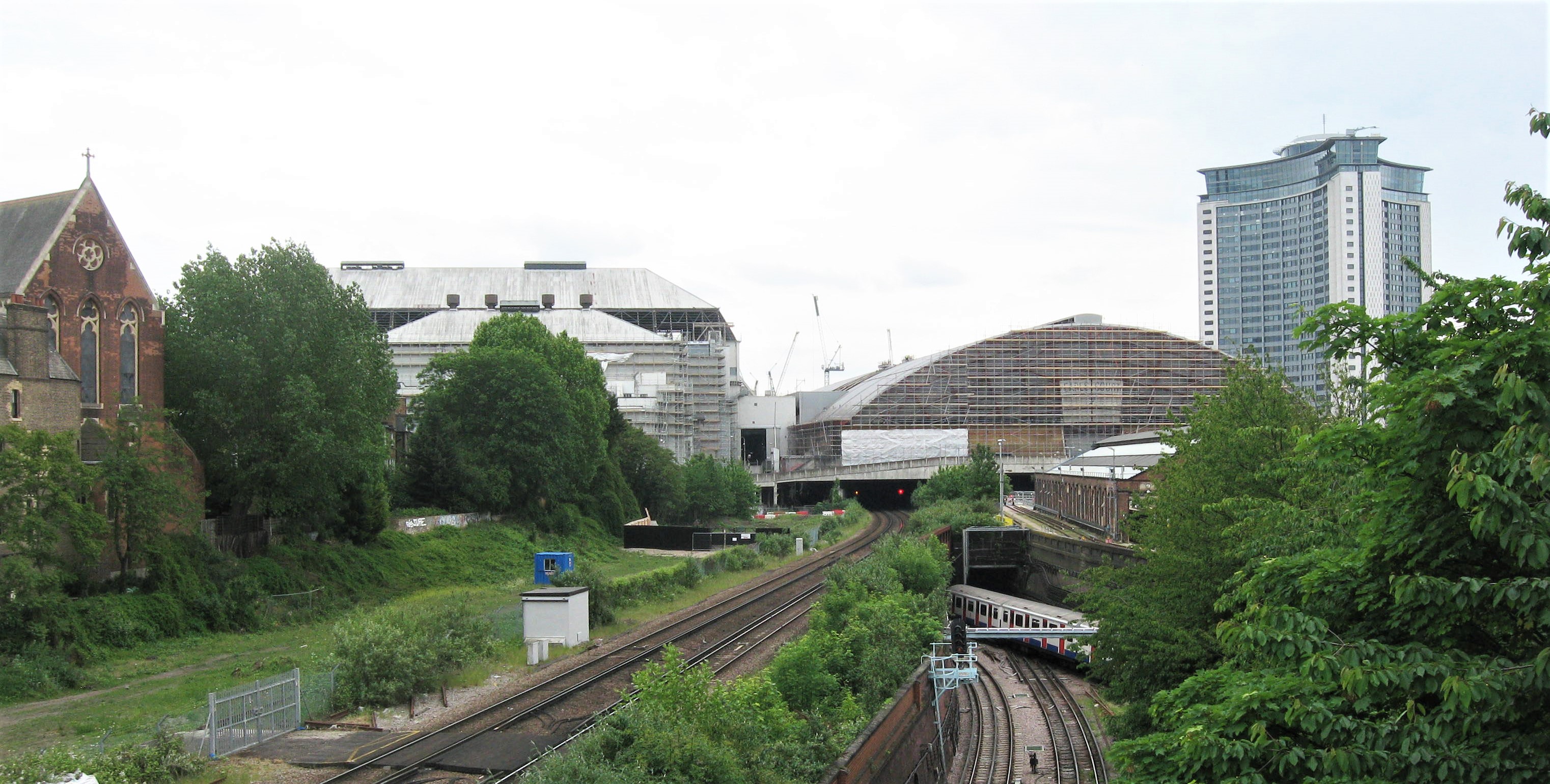 Earl's Court Demolition in progress, general view from Cromwell Road Flyover in June 2015 with original 1936 'Earl's Court 1' on left and 1990 'Earl's Court 2' on right, both sheeted for demolition