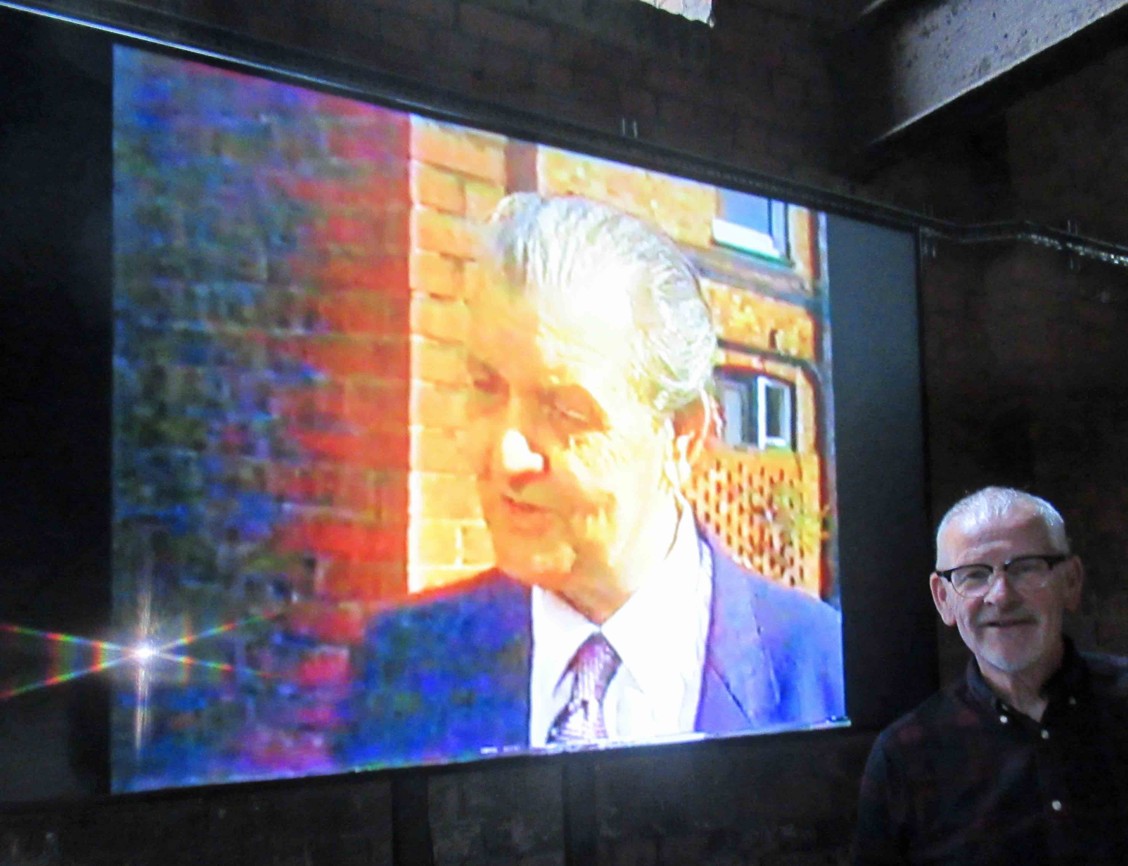 Gerard Donnachie watching the video of his father in the pump house